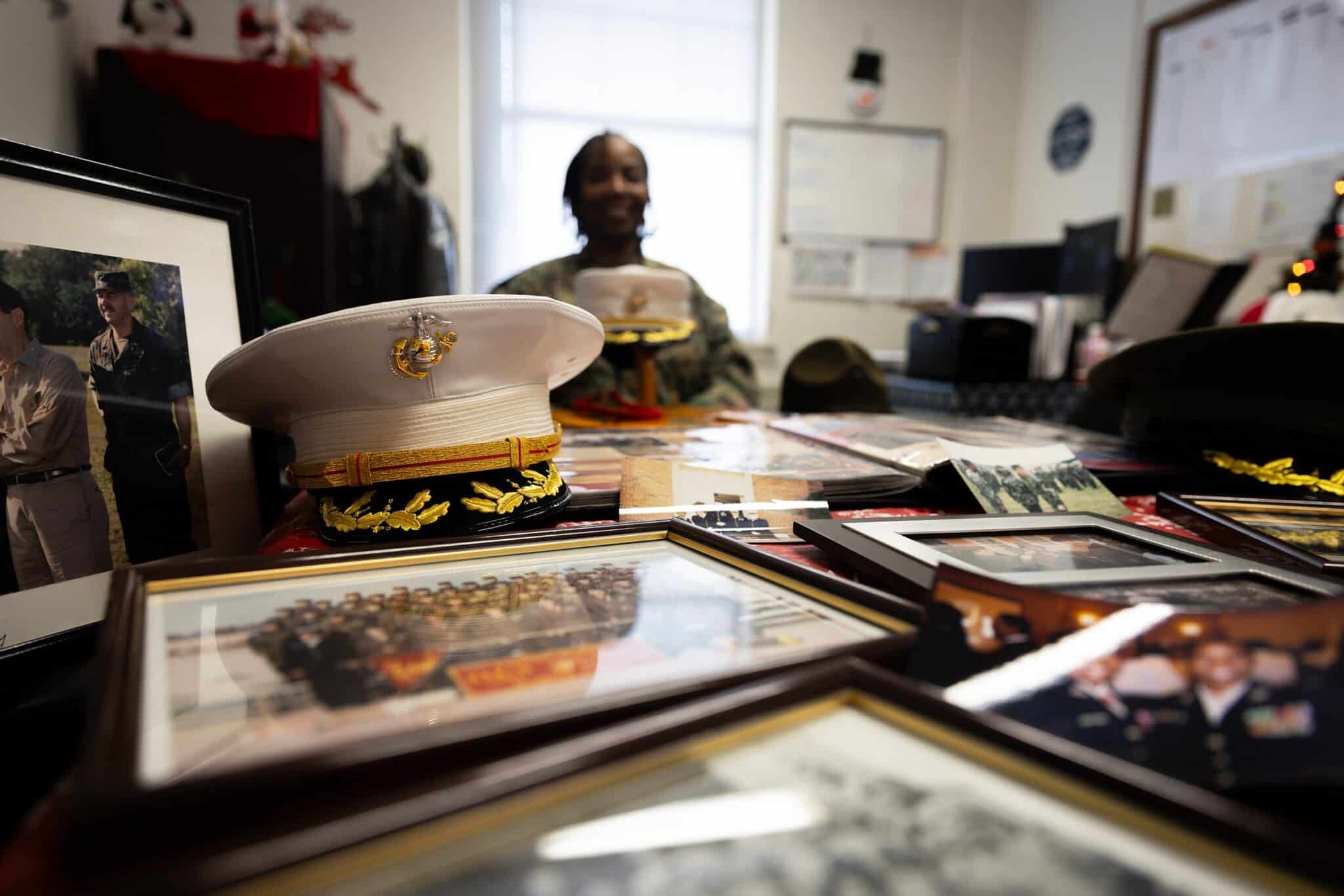 Un chapeau de l’uniforme Dress Blues du Corps des Marines posé sur une table entourée de photos et souvenirs de la lieutenant-colonel Rhonda C. Martin