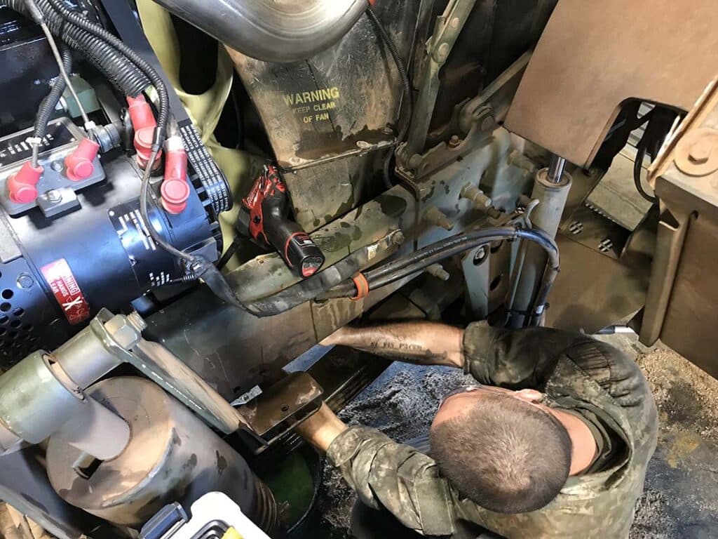 Un mécanicien de véhicules blindés en maintenance lors d’une intervention sur un FMTV à Hawaii, mai 2018.