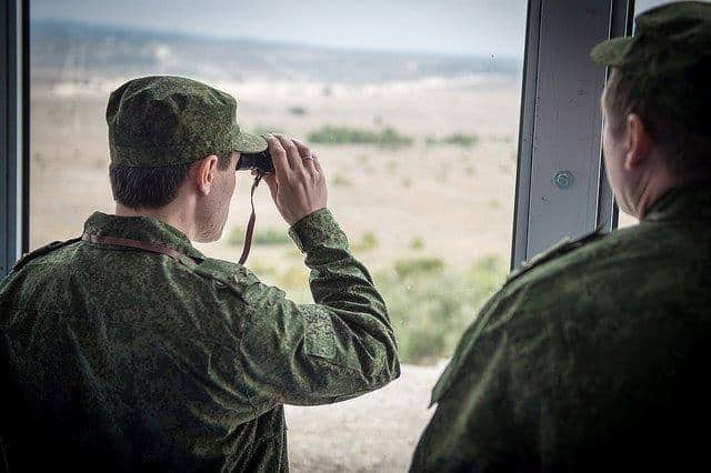 Russian military observers scan the horizon during the...