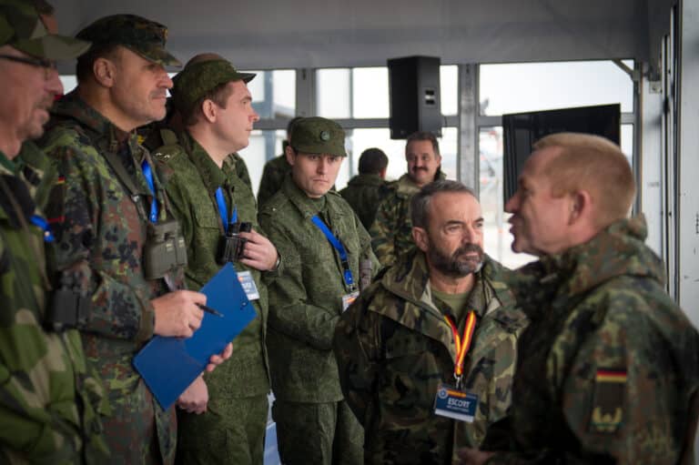 Russian military observers listen to a German officer...