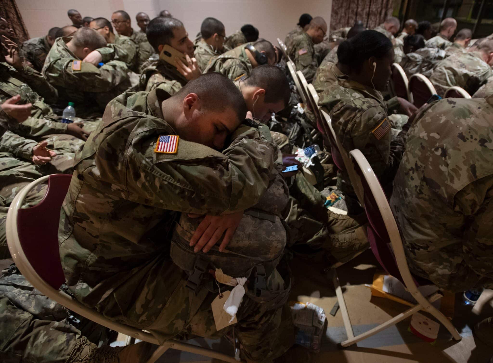 Un soldat en formation tente de dormir en attendant un transport, Joe E. Mann Ballroom, 18 décembre. Il fait partie des milliers de soldats en formation initiale qui rentrent chez eux pour les fêtes.