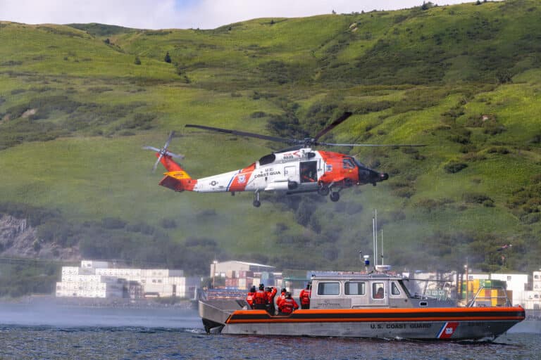 A U.S. Coast Guard MH-60 Jayhawk helicopter, a 38-foot...