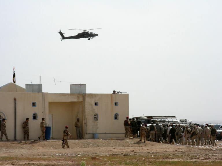 An AH-64 Apache hovers over Fort Karmashia during a...