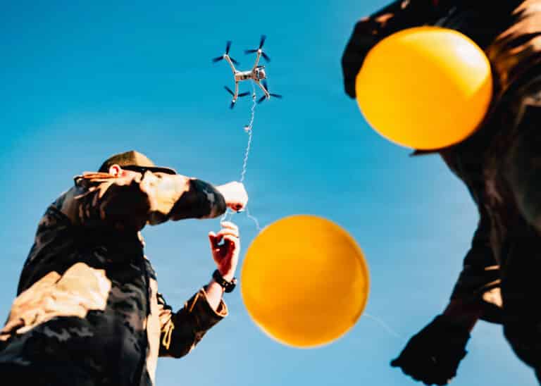 U.S. Air Force Airmen attach balloons to a drone during...