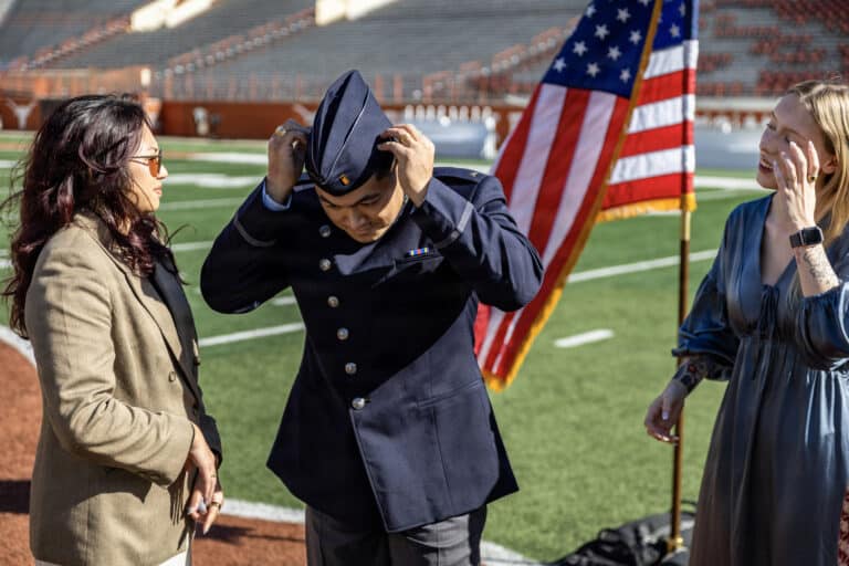 Cadet Kimo Martinez adjusts his flight cap prior to his...