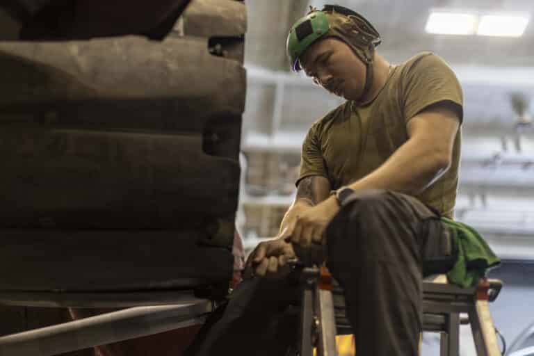 A U.S. Sailor conducts maintenance on an F/A-18E Super...